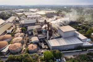 Aerial view of sugar processing plant with pollution smoke from chimney and tank warehouse in agricultural industrial factory photo