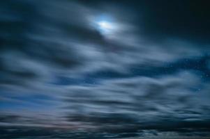 Movement of cloudy blowing through the blue sky with stars and moonlight at night