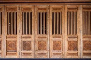 puerta de madera envejecida con dragón tallado en templo chino foto