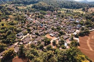 vista aérea de la aldea rural local en el valle en el campo lejano entre la selva tropical foto