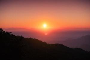 Sunrise over mountain with colorful sky in tropical rainforest at national park in the morning photo