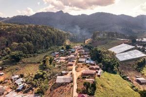 Aerial view of local rural village in the valley on faraway at countryside among the tropical rainforest photo