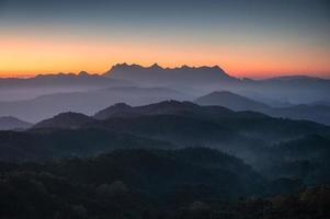 Scenery of Doi Kham Fah viewpoint with sunrise over Doi Luang Chiang Dao mountain with foggy in tropical rainforest at national park photo