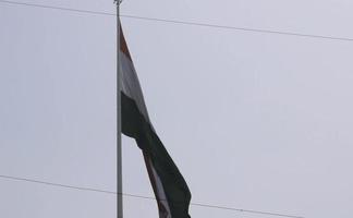 indiase vlag die hoog vliegt met trots in de blauwe lucht, indiase vlag wappert, indiase vlag op onafhankelijkheidsdag en republiek dag van india, tilt-up shot, wuivende indische vlag, vliegende indiase vlaggen video