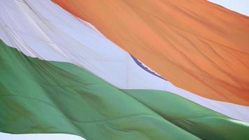 indiase vlag die hoog vliegt met trots in de blauwe lucht, indiase vlag wappert, indiase vlag op onafhankelijkheidsdag en republiek dag van india, tilt-up shot, wuivende indische vlag, vliegende indiase vlaggen video