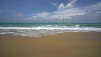 Strandbereich. Schaumige Wellen mit Himmel und Wolken. schöner tropischer Strand. erstaunliche Sandküste mit weißen Meereswellen. natur, seelandschaft und sommerkonzept. video