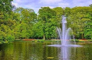 fuente en el estanque con árboles verdes, parque keukenhof, lisse, holanda foto