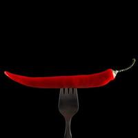 Fork and chili pepper on it photo