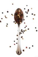 Metallic spoon and dried pepper grains photo