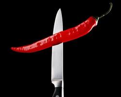 Red chili pepper and knife photo