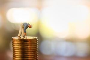 Business, Money, Planning and Saving Concept. Close up of  worker cleaning and painting on top of stack of gold coin with copy space. photo