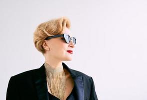 fashionable mature woman in tuxedo and sunglasses. Make up, fashion, anti aging concept photo