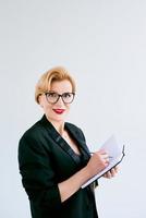 Mature beautiful business woman making plans and notes on white background. Education, business, management concept photo