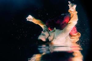 man doing yoga in a swimming pool underwater photo