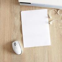 A4 blank white pperon table with laptop and mouse photo