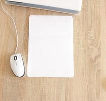 A4 blank white pperon table with laptop and mouse photo