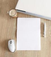 A4 blank white pperon table with laptop and mouse photo