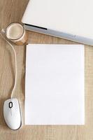 A4 blank white pperon table with laptop and mouse photo