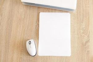 A4 blank white pperon table with laptop and mouse photo
