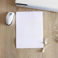 A4 blank white pperon table with laptop and mouse photo