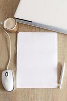 A4 blank white pperon table with laptop and mouse photo