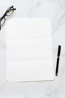A4 format paper with glasses and pen on table photo