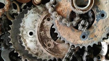 viejas cadenas de metal y ruedas dentadas bordeaban el taller de reparación de bicicletas con manchas negras de aceite. foto