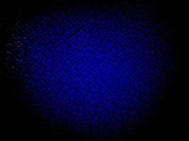 abstract blue wall or material is cracked and damaged with black gradient pattern. photo