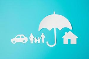 Umbrella cover family, home and Car shape paper on blue background. International day of families, Healthcare, wellness and Insurance concept photo