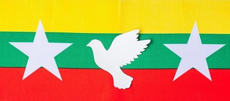 Support for Myanmar people, peace dove with flag of Myanmar. Freedom, stop war, dictatorship and democracy concepts photo