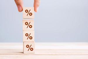 business man Hand putting wood cube block with percentage symbol icon. Interest rate,  financial, ranking and mortgage rates concept photo