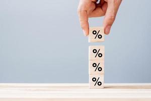 business man Hand putting wood cube block with percentage symbol icon. Interest rate,  financial, ranking and mortgage rates concept photo