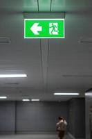 Fire Emergency exit sign on the wall inside building at subway train station. Safety concept photo