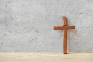 cruz de madera en el fondo de la mesa, reza por las bendiciones de dios. religión cristiana, crucifijo y concepto de fe foto