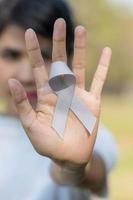 Brain Cancer Awareness month, woman hand holding grey color Ribbon for supporting people living. Healthcare and World cancer day concept photo