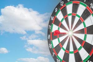 Red dart hitting a target on center of Bullseye or Dartboard. Business, competition, goal, success and marketing concept photo