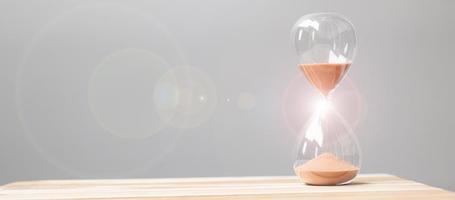 Hourglass on table office with copy space, Sand flowing through the bulb of Sandglass measuring the passing time. countdown, deadline, Life time and Retirement concept photo