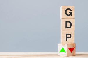 wood cube block with GDP text Gross domestic product to UP and Down arrow symbol icon. Financial, Management, Economic and business concepts photo