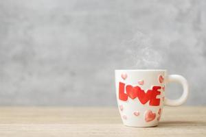 taza de café en el fondo de la mesa de madera por la mañana, espacio en blanco para el texto. día internacional del café, feliz día de san valentín y concepto de rutina diaria foto