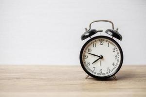 Vintage alarm clock on wooden table background and copy space for text. Activity, daily routine, morning, workout and Work life balance concept photo