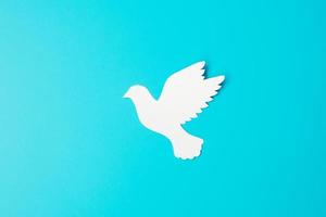 Dia Internacional de la Paz. pájaro paloma de papel blanco sobre fondo azul. libertad, esperanza y día mundial de la paz 21 de septiembre conceptos. foto