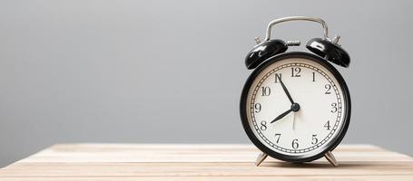 Vintage alarm clock on wooden table background and copy space for text. Activity, daily routine, morning, workout and Work life balance concept photo