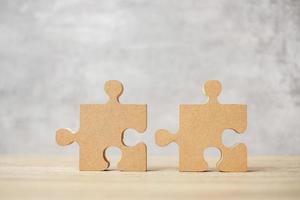 connecting couple puzzle piece, wood jigsaw on table. Business solutions, mission, success, goals and strategy concepts photo