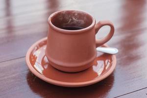 taza de café o té caliente sobre una mesa de madera por la mañana con fondo de montaña y naturaleza foto
