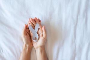 Brain Cancer Awareness month, woman hand holding grey color Ribbon for supporting people living. Healthcare and World cancer day concept photo