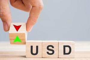 business man Hand change wood cube block with USD US Dollar text to UP and Down arrow symbol icon. Exchange, financial, currency and Cut loss concept photo