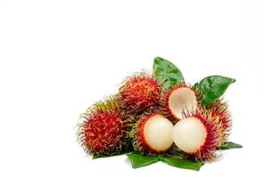 Closeup of fresh red ripe rambutan Nephelium lappaceum with leaves isolated on white background. Thai dessert sweet fruits. Tropical fruit. photo