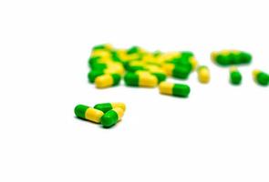 Green, yellow tramadol capsule pills on blurred capsule pills background with copy space. Cancer pain management. Opioid analgesics. Drug abuse in teenage. photo