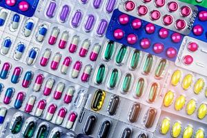 Colorful of tablets and capsules pill in blister packaging arranged with beautiful pattern with flare light. Pharmaceutical industry concept. Pharmacy drugstore. Antibiotic drug resistance. Defective. photo