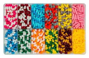 vista superior de las píldoras de cápsulas de colores en caja de plástico. medicamentos antibióticos, analgésicos, vitaminas y suplementos en cápsulas. industria farmacéutica. infecciones producción de pastillas en cápsula. foto